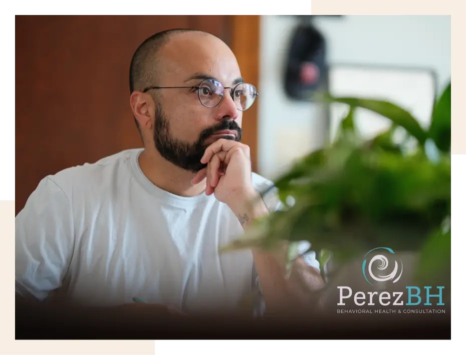 Man sitting at desk, thinking thoughtfully.
